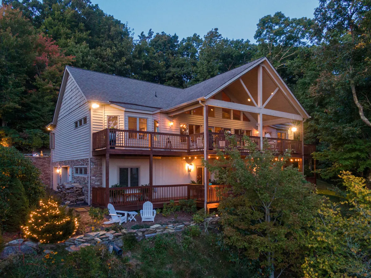 This image features a spacious balcony or deck with inviting outdoor seating, decorative lights, and abundant greenery. The ambiance is cozy and welcoming, ideal for evening gatherings, family barbecues, or quiet stargazing sessions.